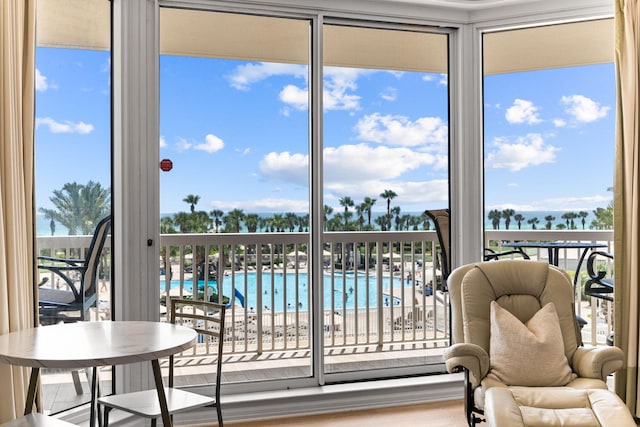 sunroom / solarium with a beach view, a water view, and a wealth of natural light