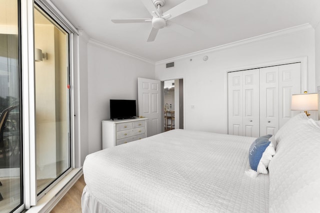 bedroom with ornamental molding, light hardwood / wood-style flooring, a closet, and ceiling fan