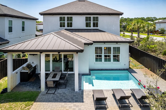 rear view of property with a fenced in pool, a patio, and a gazebo