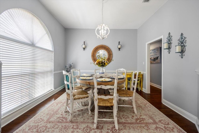 dining room featuring dark wood-type flooring, a chandelier, and a wealth of natural light