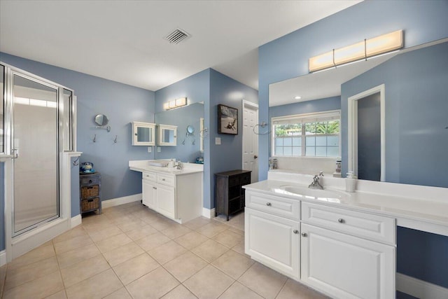 bathroom featuring an enclosed shower, double sink vanity, and tile patterned flooring