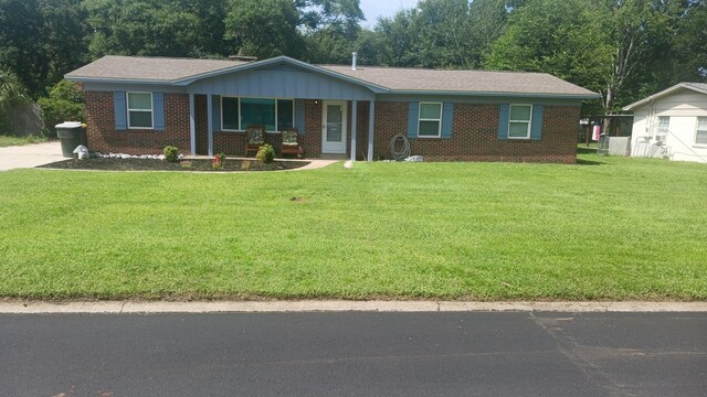 ranch-style home with covered porch and a front yard