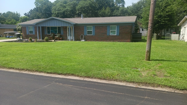 ranch-style house with a front yard and brick siding