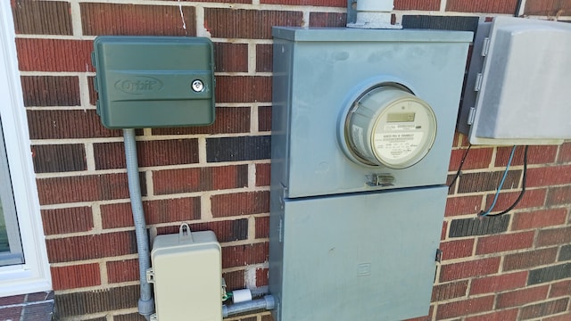 exterior details featuring brick siding and electric meter