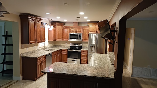 kitchen with visible vents, ornamental molding, a sink, stainless steel appliances, and a peninsula