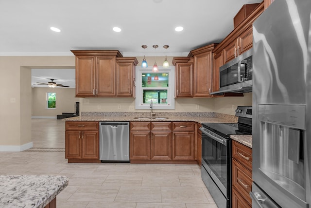111 NW Sotir St, Fort Walton Beach, FL 32548 - kitchen featuring brown cabinets, appliances with stainless steel finishes, a sink, and light stone countertops