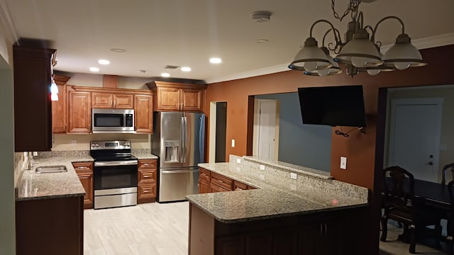 111 NW Sotir St, Fort Walton Beach, FL 32548 - kitchen with ornamental molding, appliances with stainless steel finishes, light stone counters, brown cabinets, and a notable chandelier
