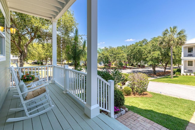 deck with a lawn and covered porch