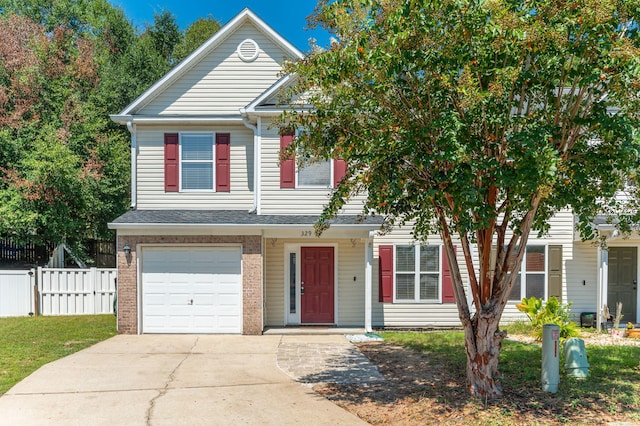 view of front of property with driveway, an attached garage, fence, and brick siding