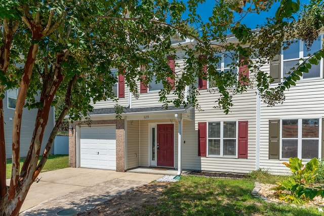 multi unit property with concrete driveway, brick siding, and an attached garage