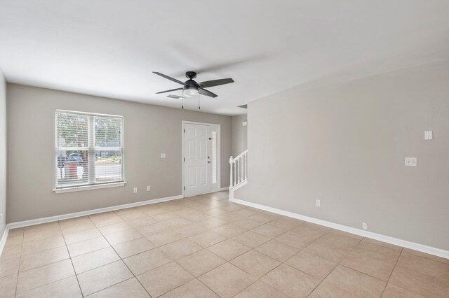 empty room with ceiling fan and light tile patterned floors