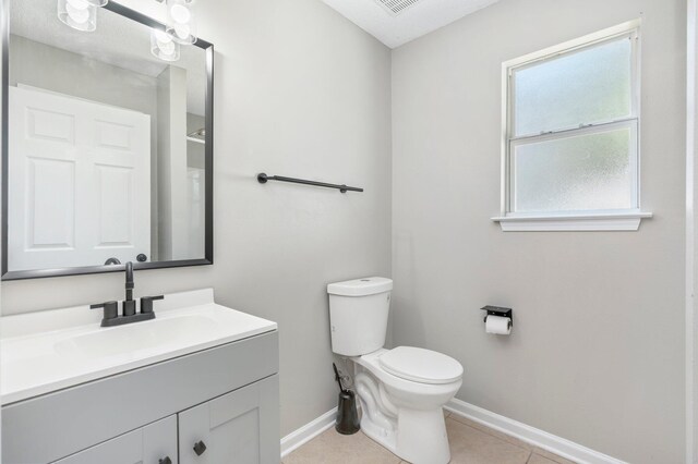 bathroom featuring vanity, a textured ceiling, toilet, and tile patterned floors