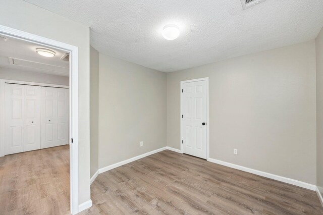 unfurnished bedroom featuring light hardwood / wood-style floors and a textured ceiling