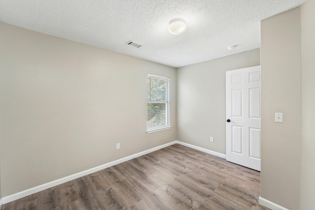 spare room with hardwood / wood-style floors and a textured ceiling