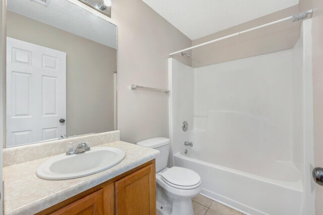 full bathroom with shower / washtub combination, a textured ceiling, toilet, vanity, and tile patterned flooring