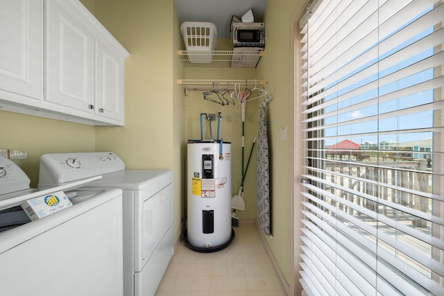 laundry area with cabinets, electric water heater, and washing machine and dryer