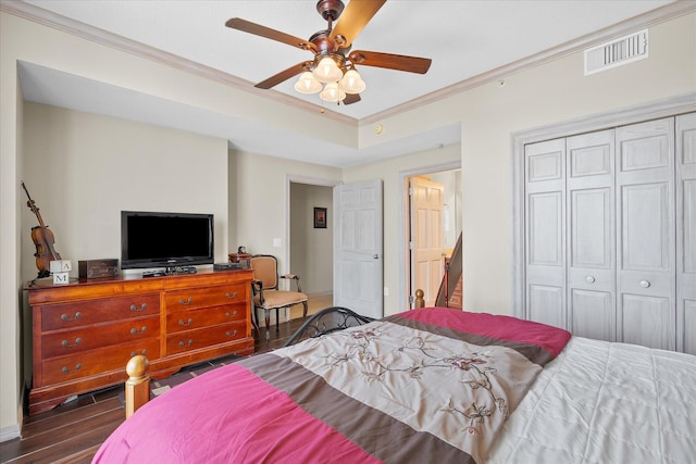 bedroom with visible vents, a ceiling fan, ornamental molding, wood finished floors, and a closet