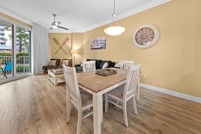 dining space featuring light wood-type flooring, crown molding, and ceiling fan