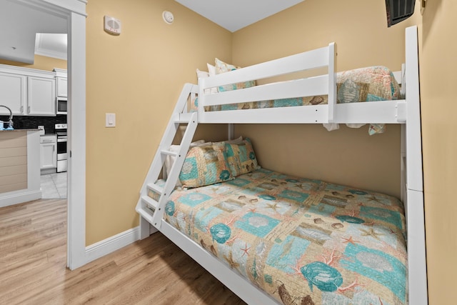 bedroom featuring light hardwood / wood-style flooring and sink