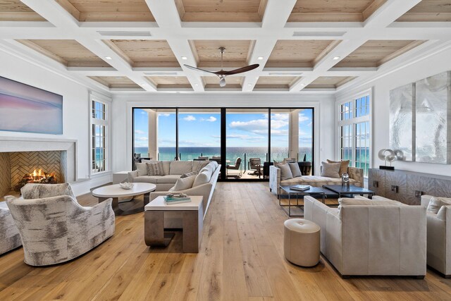 living room featuring coffered ceiling, a wealth of natural light, and light hardwood / wood-style floors