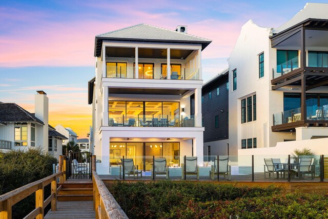 back house at dusk with a balcony