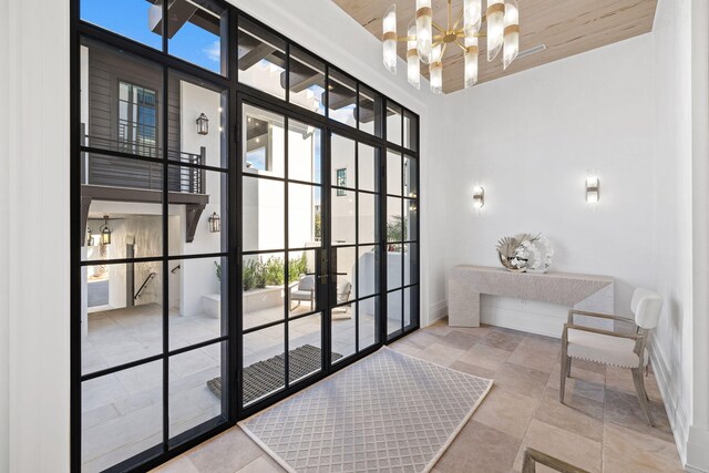 entryway featuring a notable chandelier, light tile patterned floors, wood ceiling, and a high ceiling