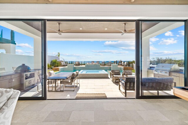 interior space with exterior kitchen, ceiling fan, and a grill