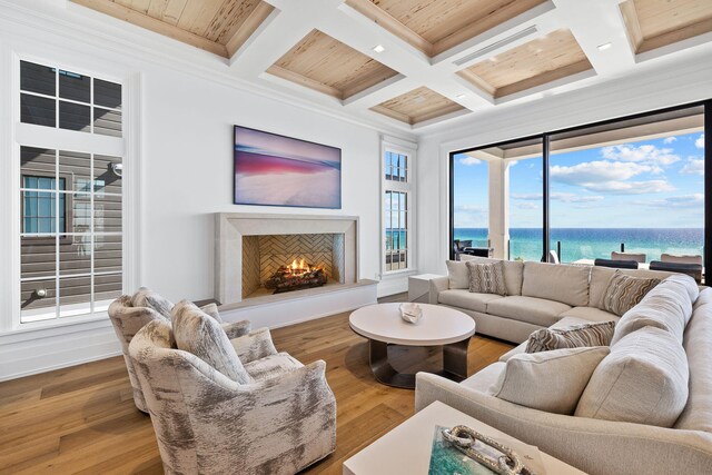 living room featuring a fireplace, crown molding, beamed ceiling, hardwood / wood-style flooring, and coffered ceiling