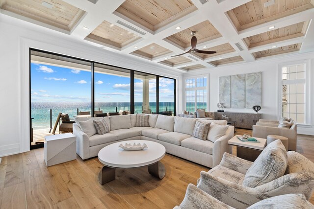 living room with ceiling fan, a water view, coffered ceiling, and light hardwood / wood-style floors