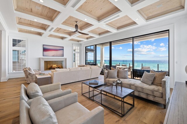 living room with ceiling fan, light hardwood / wood-style flooring, and coffered ceiling