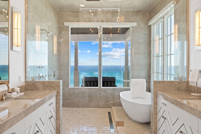 bathroom with tile walls, a washtub, a water view, and vanity