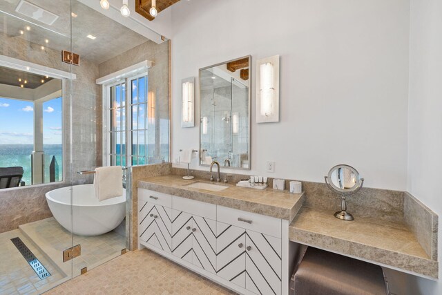 bathroom featuring a water view, vanity, a tub to relax in, and tile patterned flooring