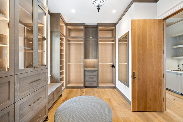 walk in closet featuring light hardwood / wood-style flooring and sink