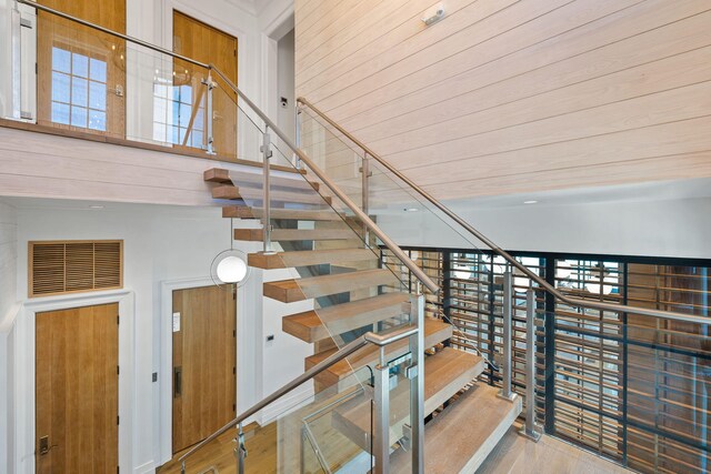 stairs featuring hardwood / wood-style flooring and a high ceiling