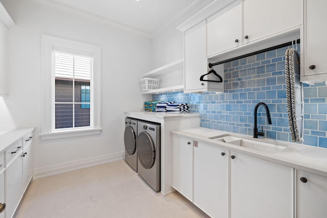 washroom featuring sink, crown molding, cabinets, and separate washer and dryer