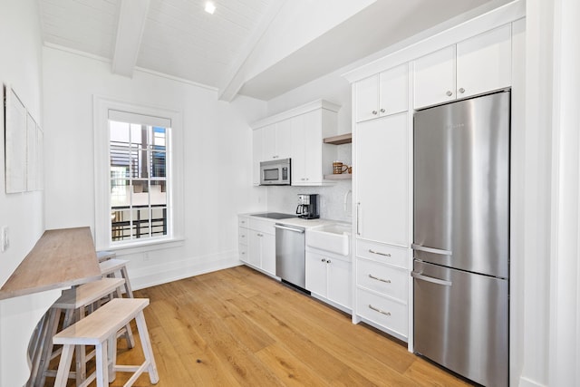 kitchen featuring white cabinets, light wood-type flooring, and stainless steel appliances