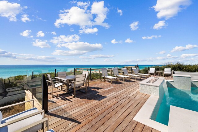 wooden deck featuring a water view and pool water feature