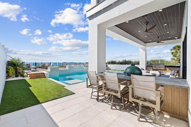 view of patio with ceiling fan and a bar