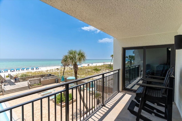 balcony with a water view and a beach view