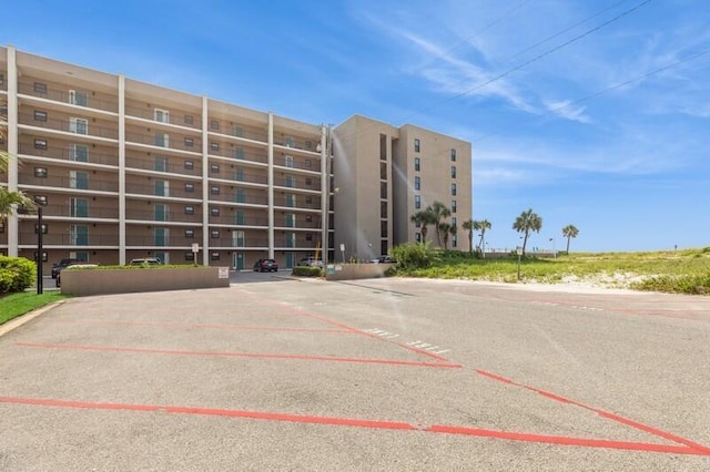 view of building exterior with uncovered parking