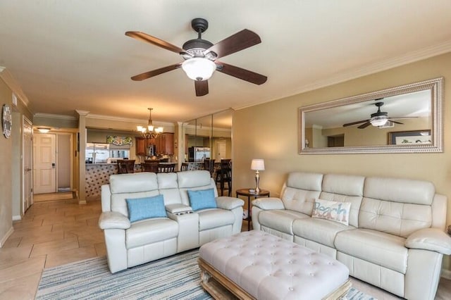 living area with ceiling fan with notable chandelier, baseboards, and ornamental molding