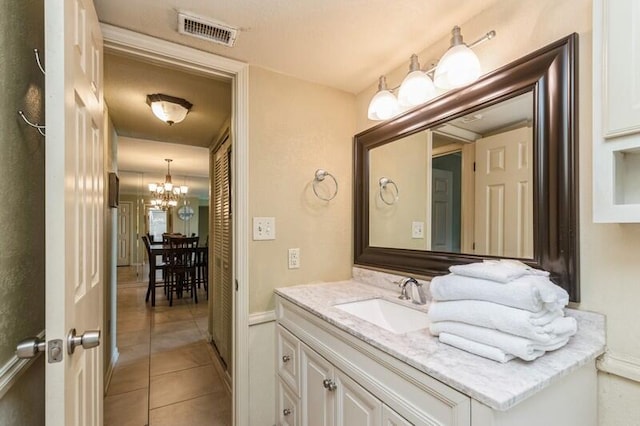 bathroom with tile patterned floors, visible vents, vanity, and a chandelier