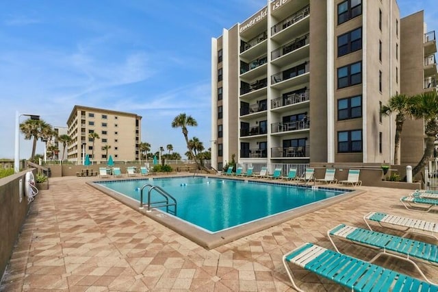 community pool featuring a patio and fence