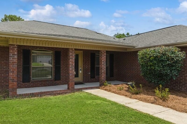 doorway to property featuring a yard and a porch