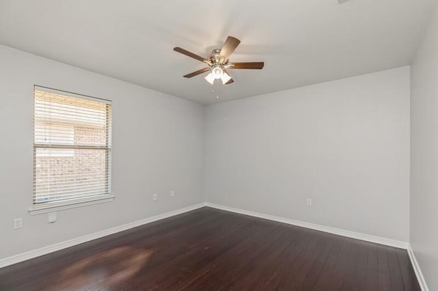 spare room with a ceiling fan, dark wood-style flooring, and baseboards