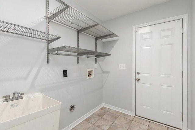 clothes washing area featuring hookup for an electric dryer, hookup for a washing machine, light tile patterned floors, and sink