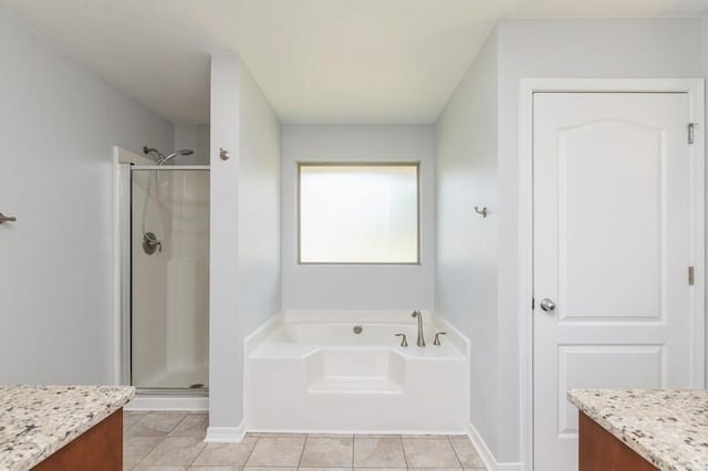 bathroom featuring a garden tub, vanity, a shower stall, baseboards, and tile patterned floors