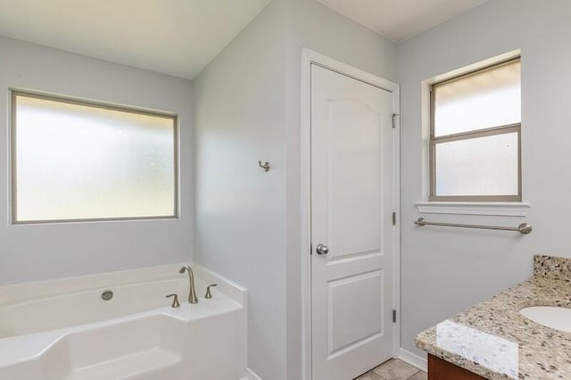 full bath with a closet, plenty of natural light, a garden tub, and vanity