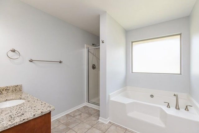 bathroom with a shower stall, vanity, tile patterned flooring, baseboards, and a bath