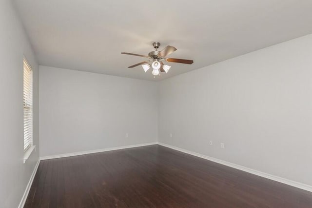 unfurnished room with ceiling fan, baseboards, and dark wood finished floors